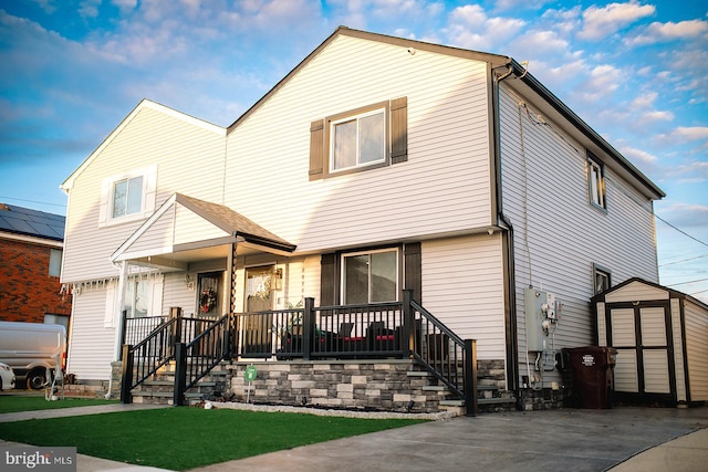 view of front of house featuring a porch and a shed