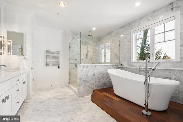 bathroom featuring crown molding, shower with separate bathtub, vanity, and tile walls