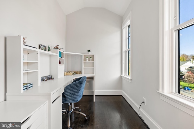 home office featuring lofted ceiling, dark wood-type flooring, and built in desk