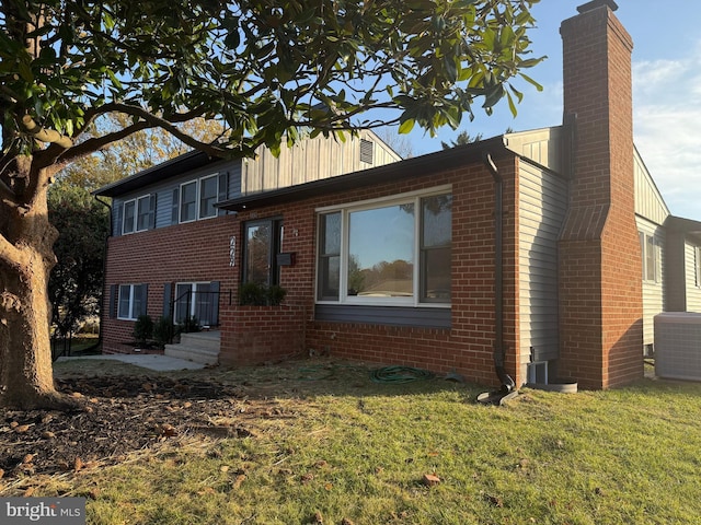 view of property exterior with a yard and central AC unit