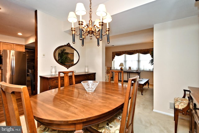 dining room featuring light carpet and a chandelier