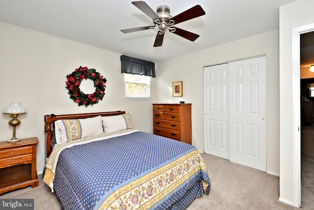 bedroom with ceiling fan, a closet, and light colored carpet