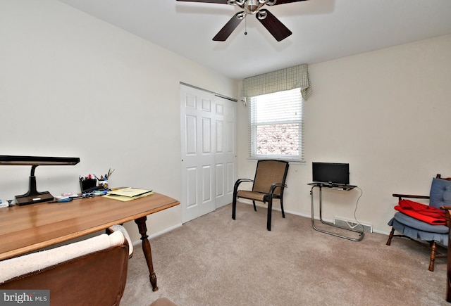 carpeted home office featuring ceiling fan