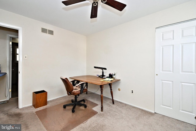 home office featuring light carpet and ceiling fan