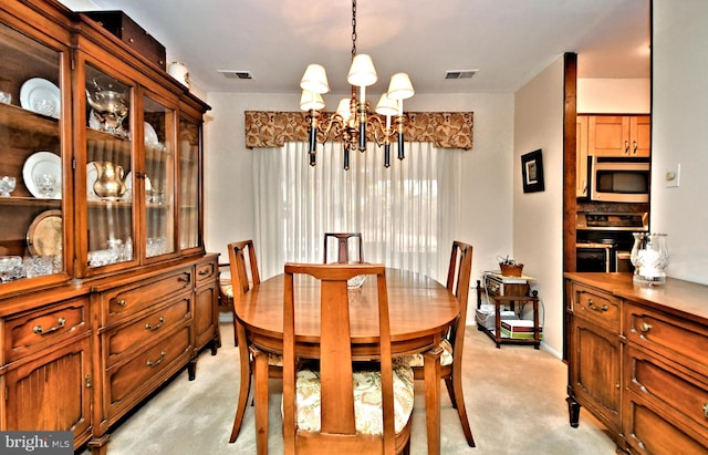 dining room featuring light colored carpet and a chandelier