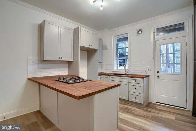 kitchen featuring white cabinets, wood counters, and backsplash