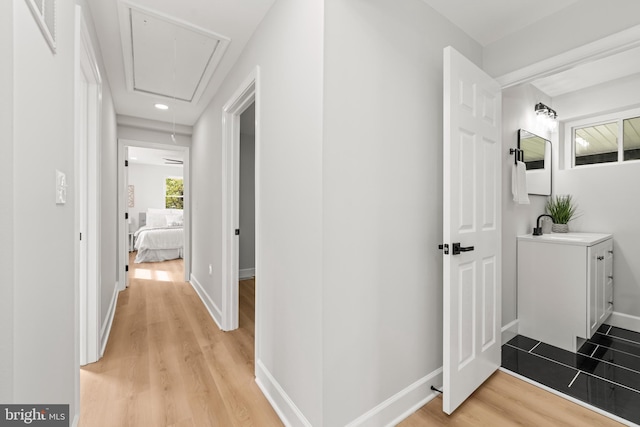 hallway with sink and light hardwood / wood-style flooring