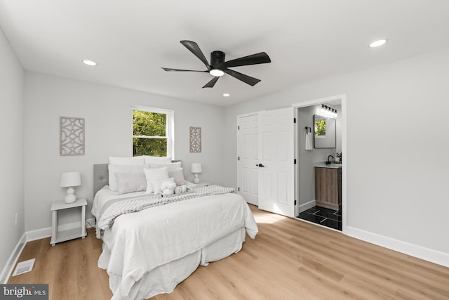 bedroom featuring wood-type flooring, connected bathroom, and ceiling fan