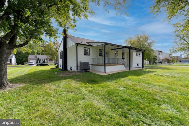 back of house featuring a yard and central AC unit