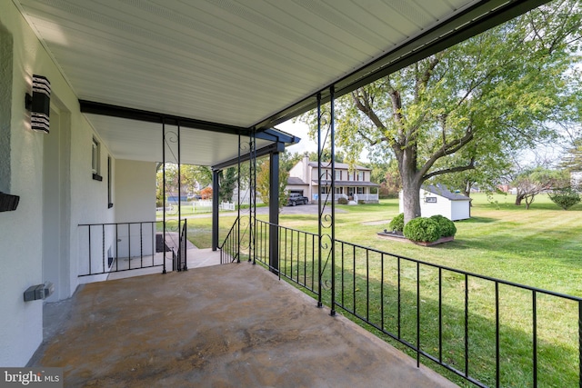 view of patio / terrace featuring covered porch and a storage unit