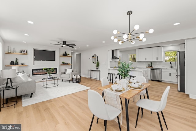 dining area with ceiling fan with notable chandelier and light wood-type flooring