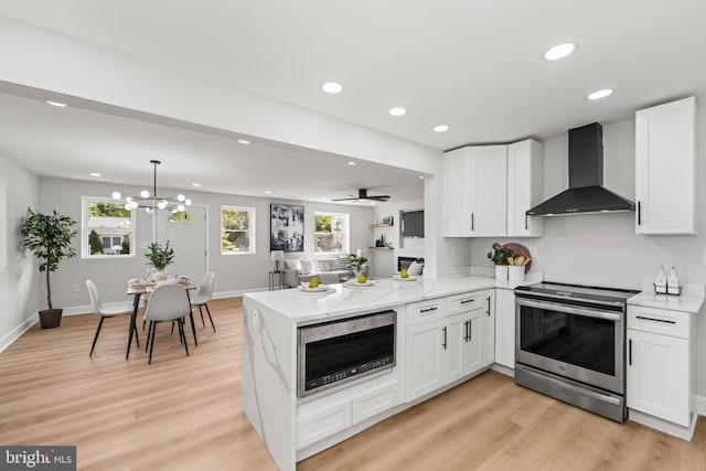 kitchen featuring white cabinetry, wall chimney exhaust hood, light hardwood / wood-style flooring, kitchen peninsula, and appliances with stainless steel finishes