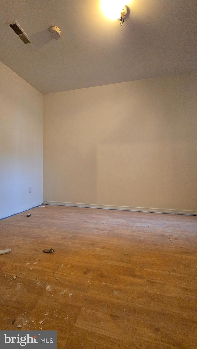 empty room with wood-type flooring and lofted ceiling