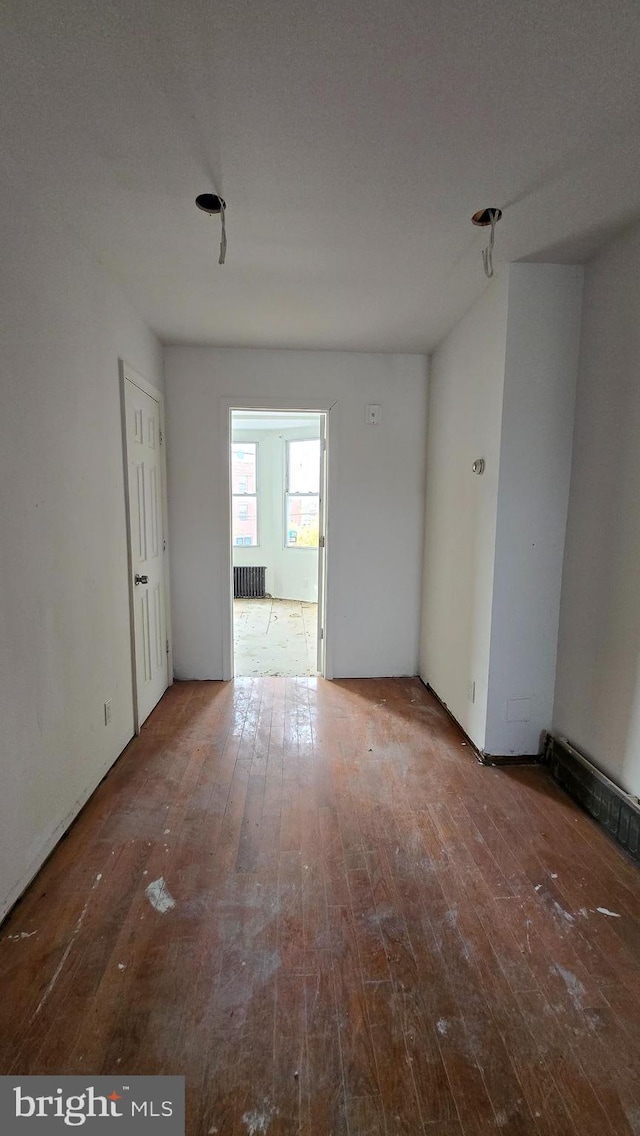 unfurnished room with hardwood / wood-style floors, radiator heating unit, and a textured ceiling