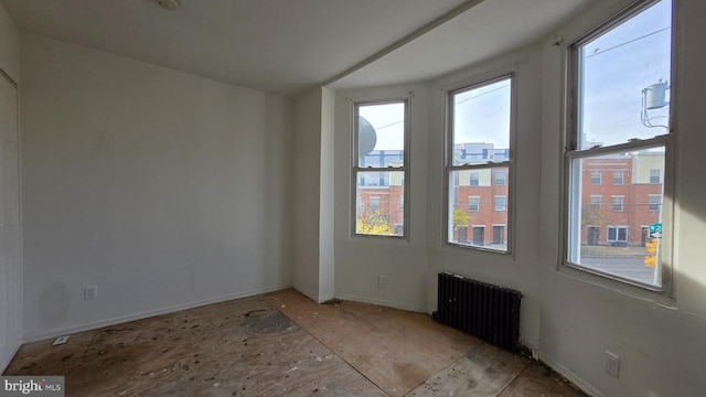 spare room featuring plenty of natural light and radiator