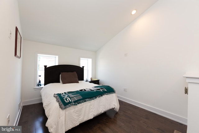 bedroom with dark wood-type flooring and lofted ceiling