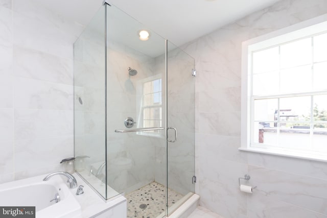 bathroom featuring plus walk in shower and a wealth of natural light