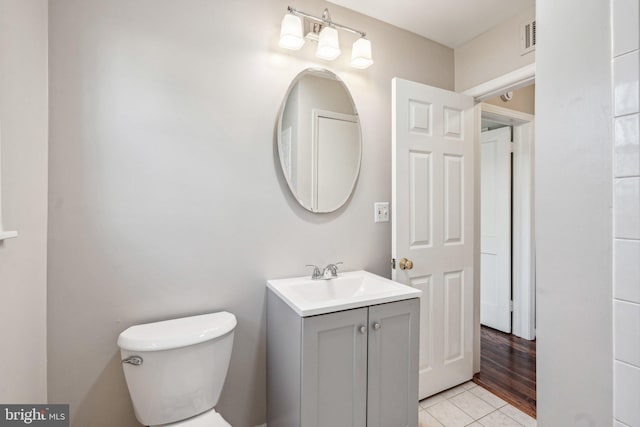 bathroom featuring hardwood / wood-style flooring, vanity, and toilet