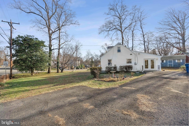 view of home's exterior featuring a yard and french doors