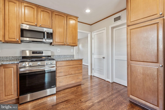 kitchen featuring appliances with stainless steel finishes, dark hardwood / wood-style floors, light stone counters, and ornamental molding