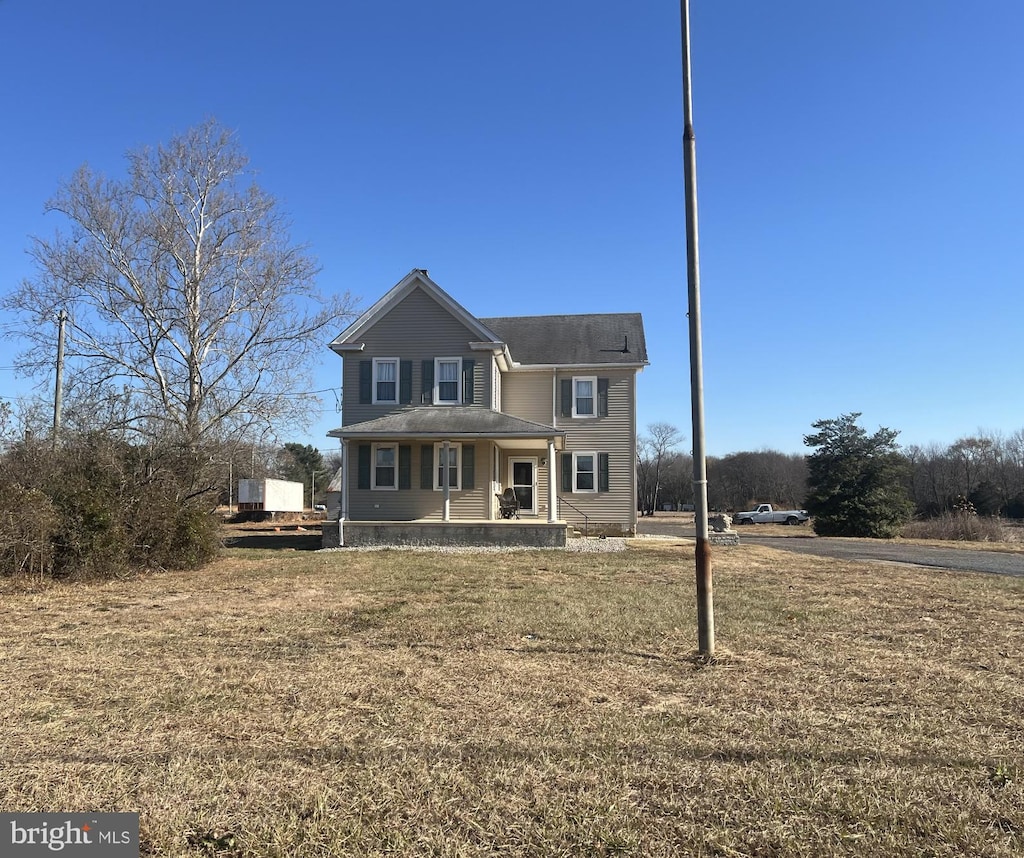 view of front property featuring covered porch and a front lawn