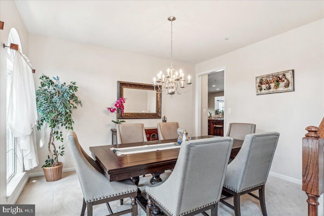 carpeted dining room featuring an inviting chandelier