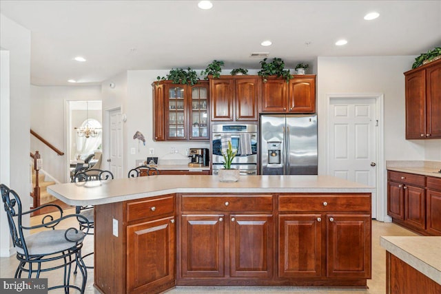 kitchen featuring a kitchen breakfast bar, a center island, stainless steel appliances, and a notable chandelier