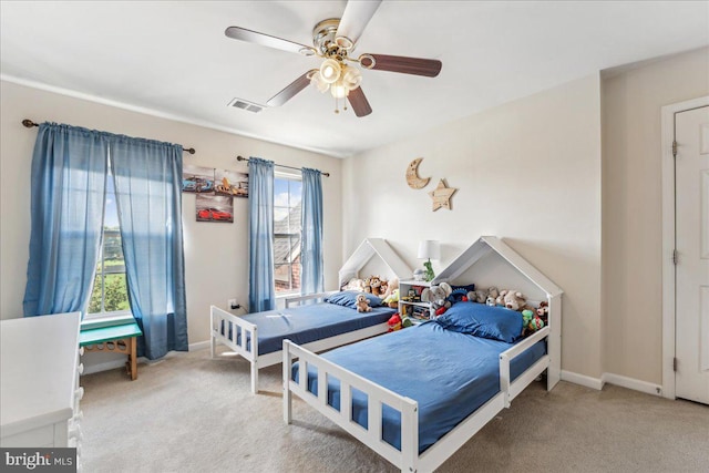 bedroom with ceiling fan, carpet floors, and multiple windows