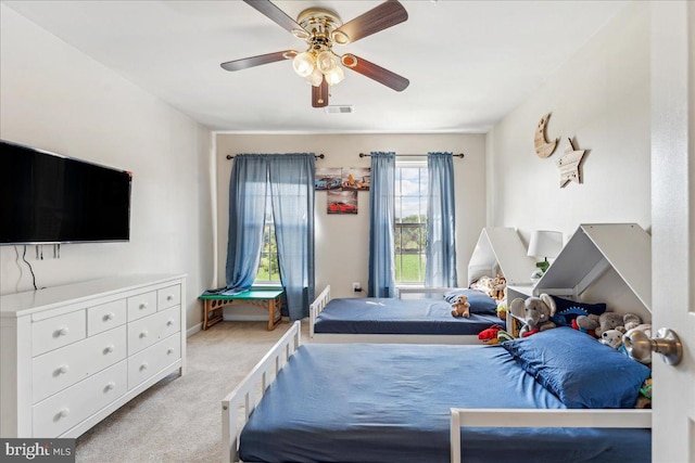 bedroom featuring ceiling fan, light carpet, and multiple windows