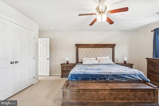 bedroom featuring a closet, light colored carpet, and ceiling fan