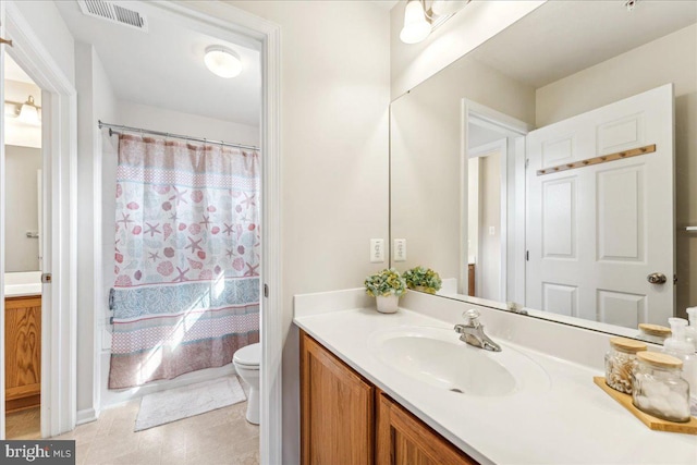 bathroom featuring tile patterned flooring, vanity, toilet, and walk in shower