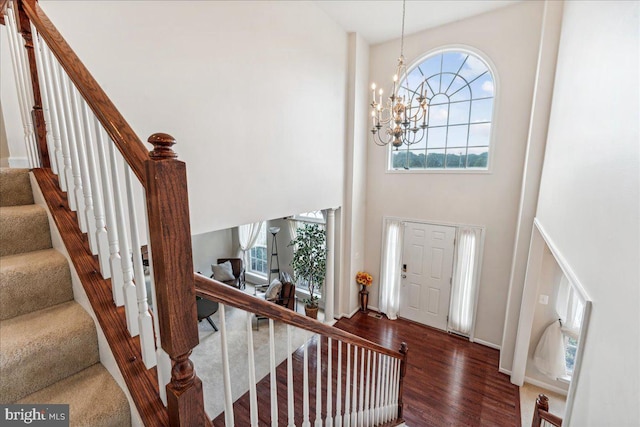 entryway featuring a high ceiling, dark hardwood / wood-style flooring, and a notable chandelier