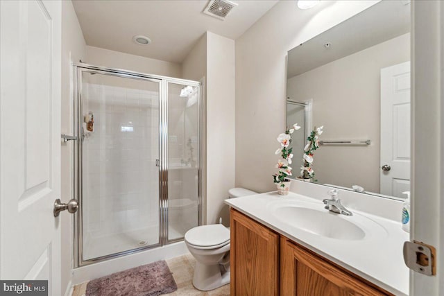 bathroom featuring a shower with door, vanity, and toilet