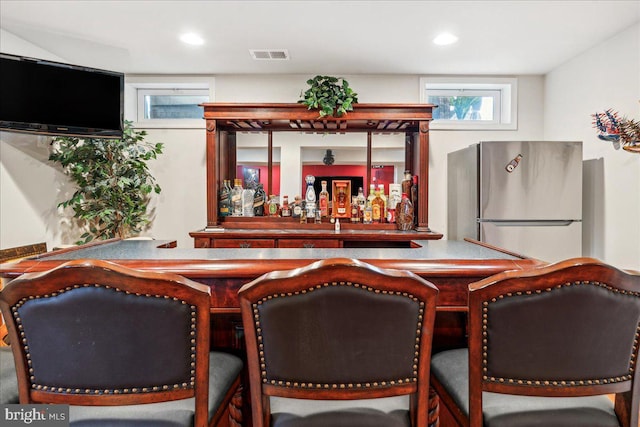 bar featuring stainless steel refrigerator