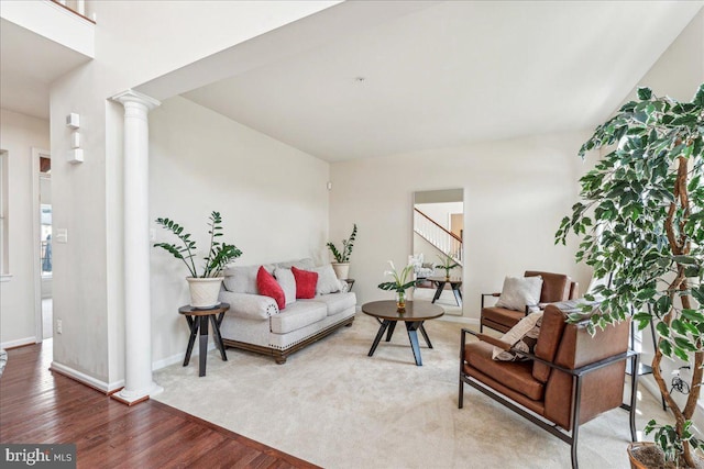 living room with ornate columns and hardwood / wood-style floors