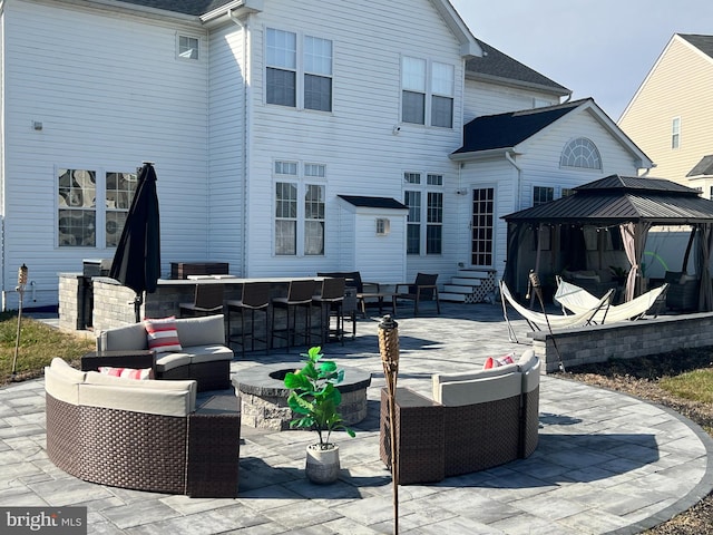 view of patio / terrace with a gazebo, an outdoor living space, and exterior bar