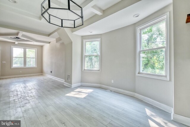 spare room with beam ceiling, ceiling fan, and light hardwood / wood-style floors