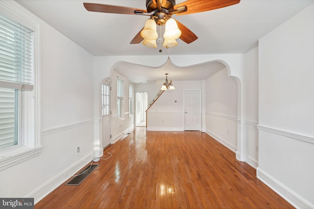 interior space with hardwood / wood-style floors and ceiling fan with notable chandelier