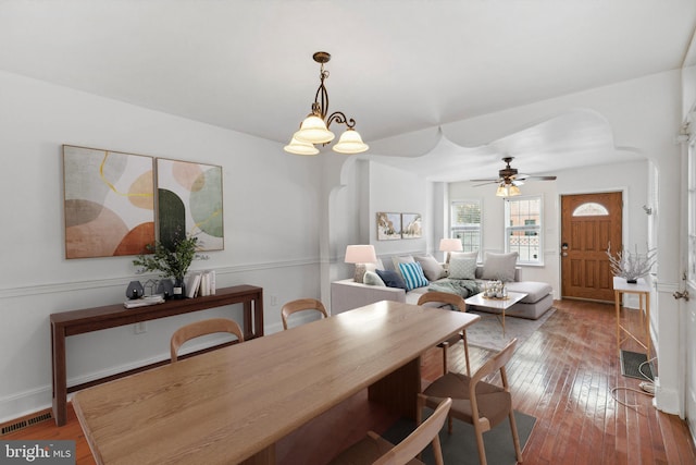 dining area featuring ceiling fan with notable chandelier and wood-type flooring