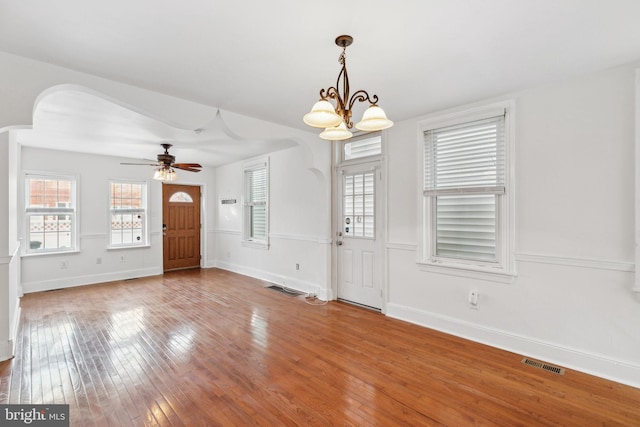 entrance foyer with ceiling fan with notable chandelier and hardwood / wood-style flooring