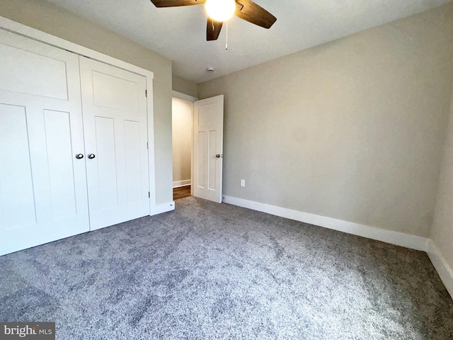 unfurnished bedroom featuring baseboards, a ceiling fan, carpet flooring, and a closet