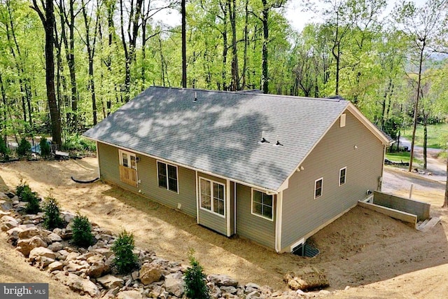 rear view of house with roof with shingles