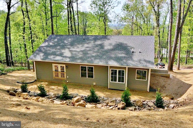 back of property with a shingled roof