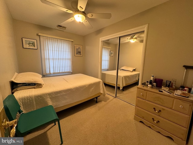 carpeted bedroom featuring ceiling fan and a closet