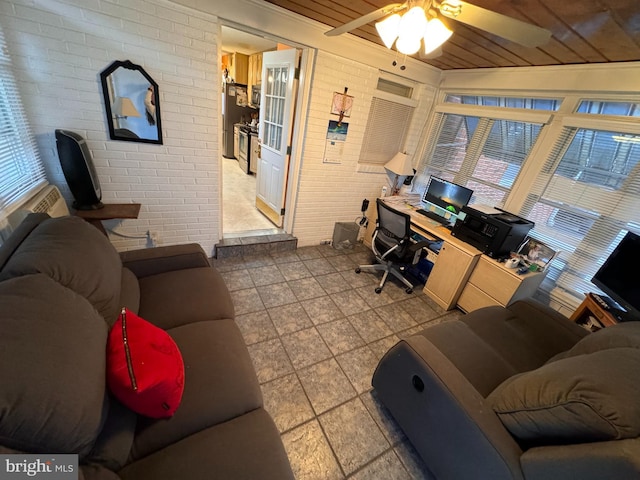 living room with ceiling fan, brick wall, and lofted ceiling