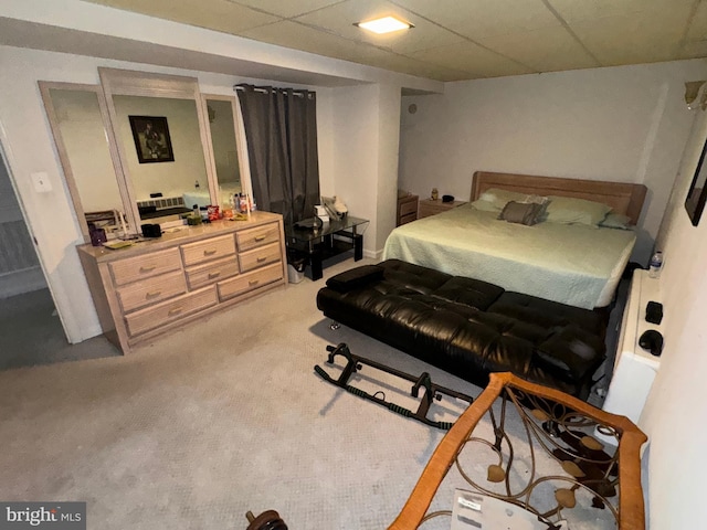 bedroom featuring light carpet and a drop ceiling