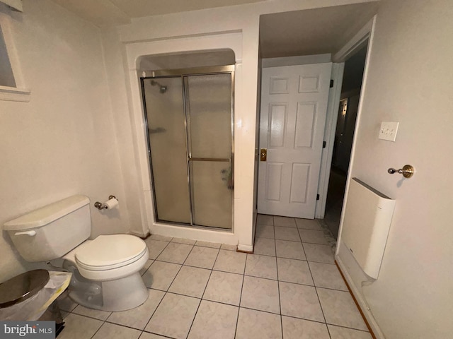 bathroom with tile patterned flooring, toilet, and walk in shower