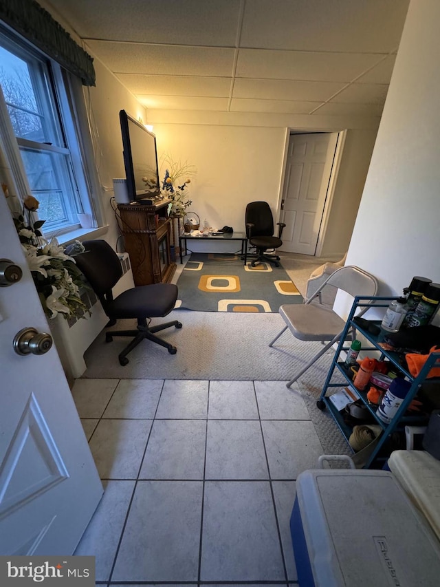 miscellaneous room featuring a paneled ceiling and light tile patterned flooring