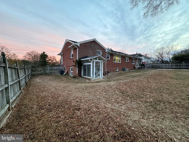 back house at dusk featuring cooling unit