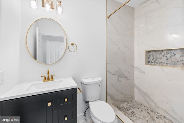 bathroom with vanity, toilet, and tiled shower